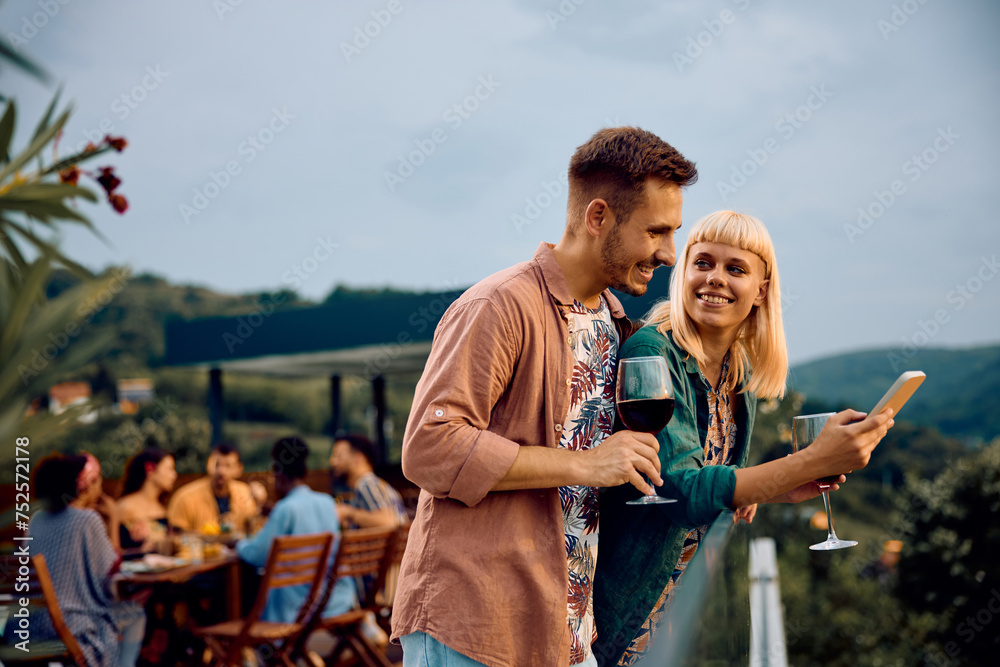 Young happy couple using smart phone on patio. Young happy couple using smart phone on patio.