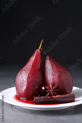 Tasty red wine poached pears and spices on grey table, closeup