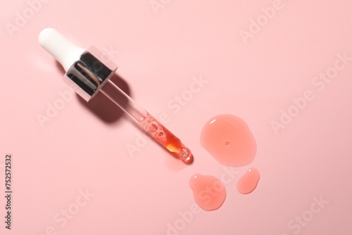 Pipette and moisturizing serum on pink background, top view