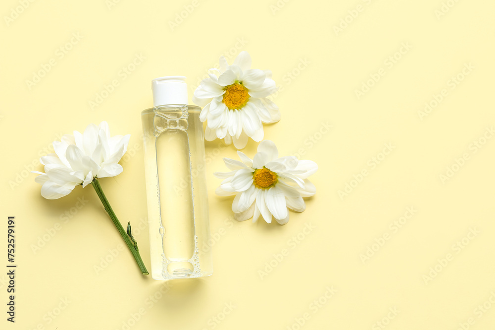 Bottle of cosmetic product with chamomile flowers on color background Bottle of cosmetic product with chamomile flowers on color background