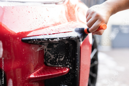 Close-up of hand car wash with brush and suds