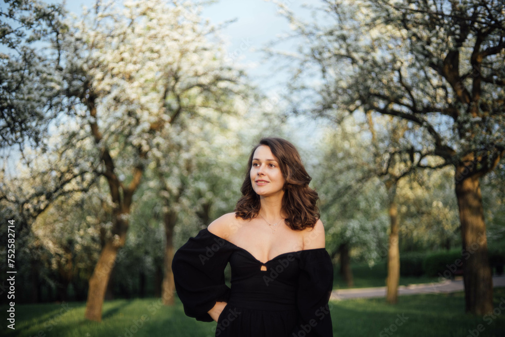 young beautiful woman in a blooming park in white blossoms in spring. young beautiful woman in a blooming park in white blossoms in spring.