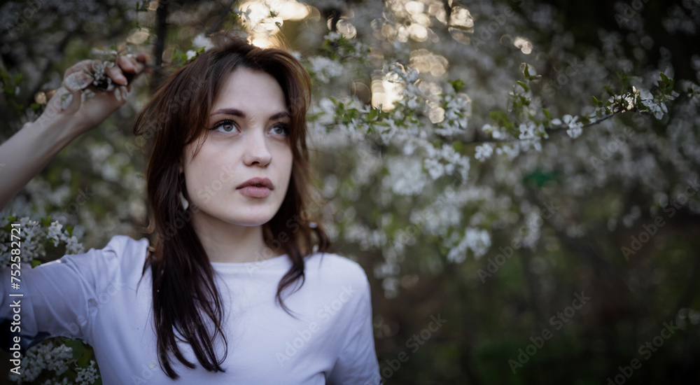 portrait of a beautiful woman in a blooming garden of trees at sunset. Beauty of a woman in nature portrait of a beautiful woman in a blooming garden of trees at sunset. Beauty of a woman in nature