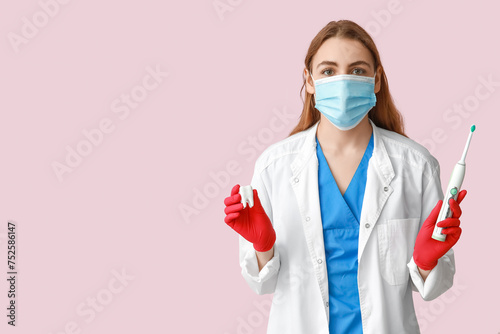 Female dentist in mask with...