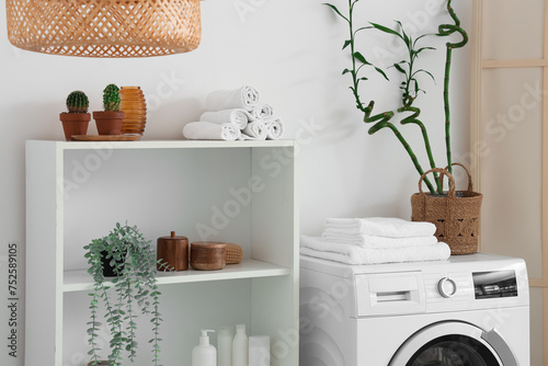 Shelving unit and washing machine in interior of bathroom © Pixel-Shot