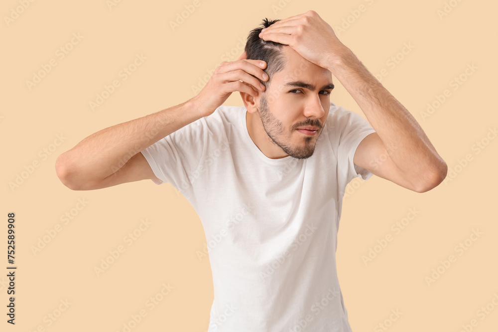 Fototapeta premium Young man with hair loss problem on beige background
