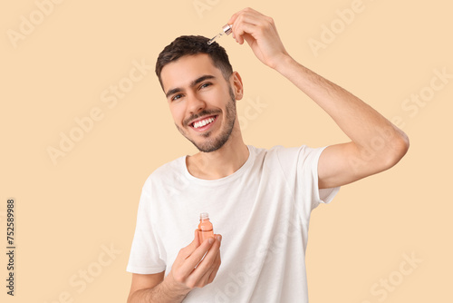 Young man applying serum fo...