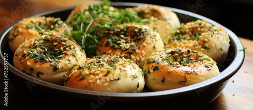 A bowl containing oven-baked garlic buns coated with olive oil, herbs, and seasonings, topped with melted cheese for a delicious and savory dish.