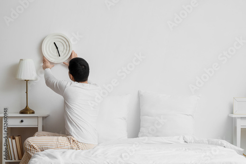 Young man with clock on lig...