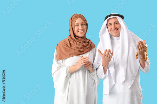 Happy Muslim couple on blue...