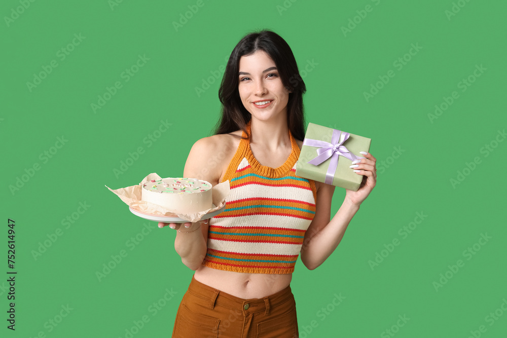 Beautiful young woman with sweet bento cake and gift box on green background. International Women's Day - obrazy, fototapety, plakaty 