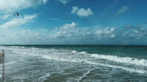 CUBA - DECEMBER 22: Kitesurfing in Varadero. Several people are kitesurfing on the beach on a cloudy day. Kites are lifted into the air by the wind. Tourists ride kiteboards in the turquoise ocean. 4К