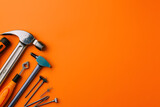 top view of a DIY home repair kit with hammer, screwdriver, and nails, isolated on a project-ready orange background, symbolizing home improvement 