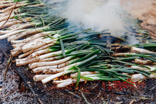 Piles of calcot, sweet onions typical Catalonia, Spain barbecue on the grill photo