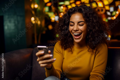 Young African American woman sitting on sofa with her phone happy black woman catching up on her social media and buying on her smartphone sitting at home