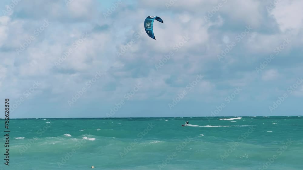 CUBA - DECEMBER 22: Kitesurfing in Varadero. Several people are kitesurfing on the beach on a cloudy day. Kites are lifted into the air by the wind. Tourists ride kiteboards in the turquoise ocean. 4К CUBA - DECEMBER 22: Kitesurfing in Varadero. Several people are kitesurfing on the beach on a cloudy day. Kites are lifted into the air by the wind. Tourists ride kiteboards in the turquoise ocean. 4К