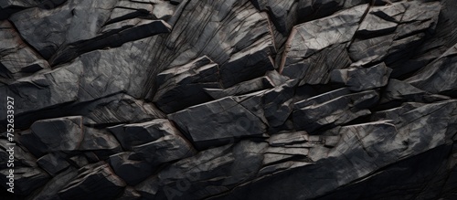 This image showcases an intricate arrangement of rocks with a captivating dark texture, captured in high definition. The rugged surfaces and contrasting tones of the rocks create a striking visual © AkuAku