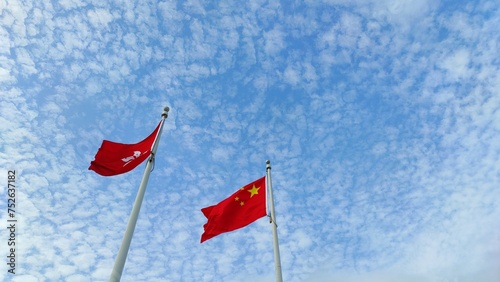 Photography Low angle view of Chinese flag and Hong Kong flag on sky background
