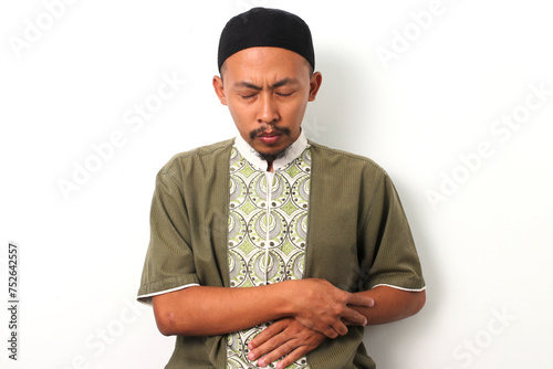 An Indonesian Muslim man in koko and peci performs salah (prayer) with reverence. Isolated on a white background photo