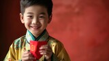 A little boy in traditional clothing with red envelope, or red pack, Hongbao, during Chinese lunar new year celebration.