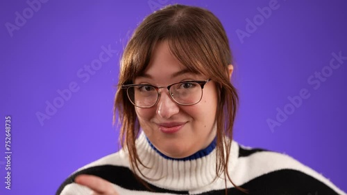 Closeup portrait of smug young woman, 20s, pointing her finger knowingly isolated on purple background photo
