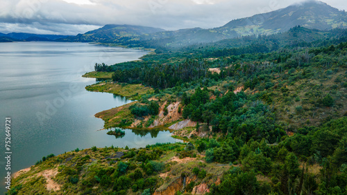 Aerial view of serene Embalse de Tominé, Guatavita, Cundinamarca, surrounded by lush greenery and mountains under a cloudy sky photo