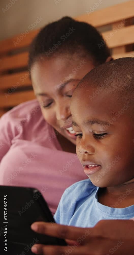 Home, black family and mother with son, tablet and typing with connection or social media. Apartment, parent and mama with boy or kid with tech or online reading with child development or digital app Home, black family and mother with son, tablet and typing with connection or social media. Apartment, parent and mama with boy or kid with tech or online reading with child development or digital app