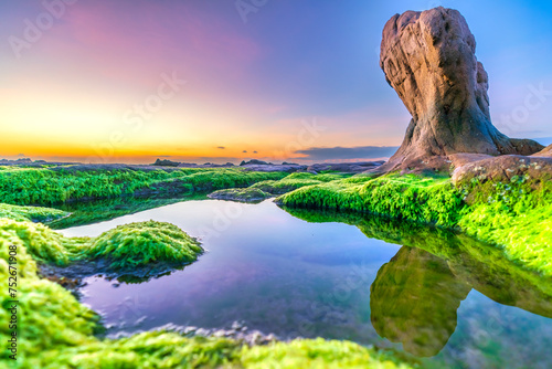 Landscape of rocky beach at sunrise with moss and pebbles on Co Thach beach, a famous beach in Binh Thuan province, central Vietnam photo