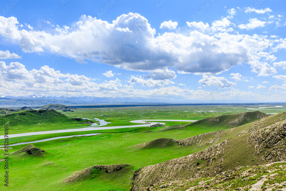 Curved river and green grassland with mountain natural landscape in Xinjiang