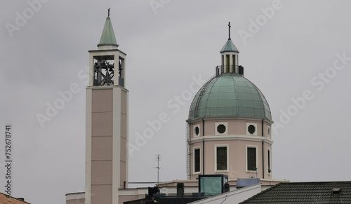 Campanile e cupola chiesa nel cielo grigio photo
