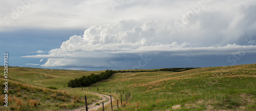 Wide shot of a small storm over a vast prairie landscape.