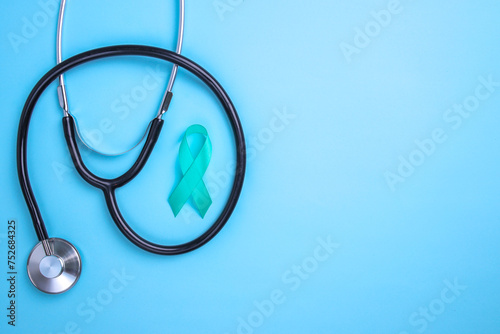 Teal awareness ribbon and stethoscope to support cancer survivor. Ovarian Cancer month, cervical cancer day.