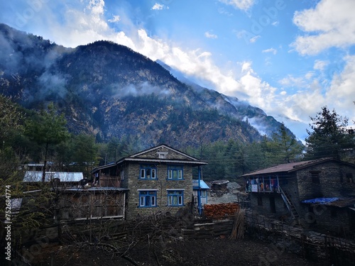 village surrounded by majestic mountain with blue sky in background