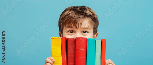 happy boy next to some books on a blue background photo