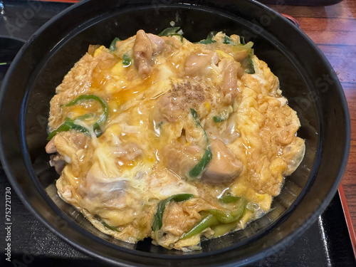 Japanese style omelet with pork and vegetables in a black bowl