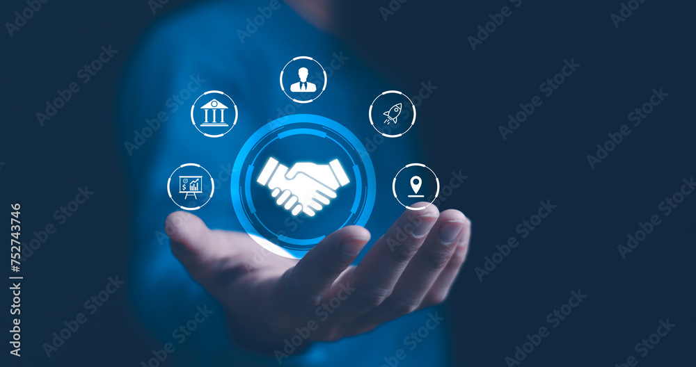 A businessman presents a holographic global partnership concept, with interconnected icons floating above his hand. Business partnerships concept. Business collaboration strategies.