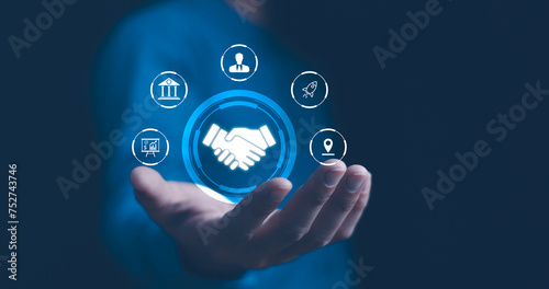 Obraz na płótnie A businessman presents a holographic global partnership concept, with interconnected icons floating above his hand. Business partnerships concept. Business collaboration strategies. w salonie