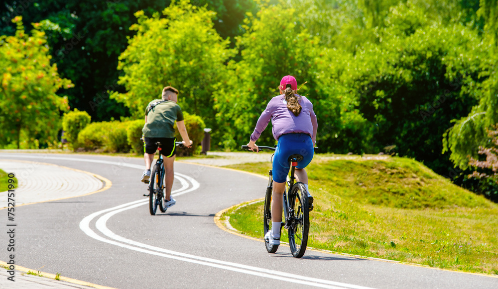 Cyclists ride on the bike path in the city Park
