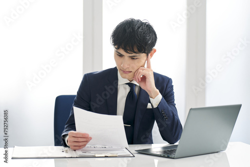 仕事の書類の審査をするビジネスマン photo
