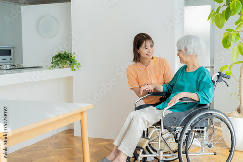 車椅子に乗った女性をサポートする介護士 photo