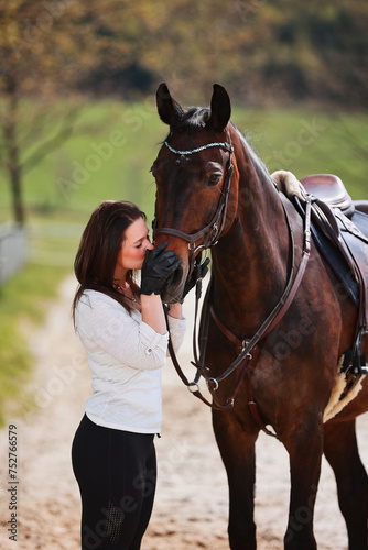 Young Frtau rider with brown long hair in portrait with her horse on the riding arena. © RD-Fotografie