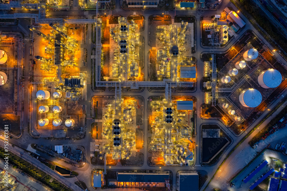 Oil refinery plant industry and port, Aerial view oil and gas petrochemical industrial, Refinery factory oil storage tank and pipeline steel at night, Ecosystem and healthy environment concepts.
