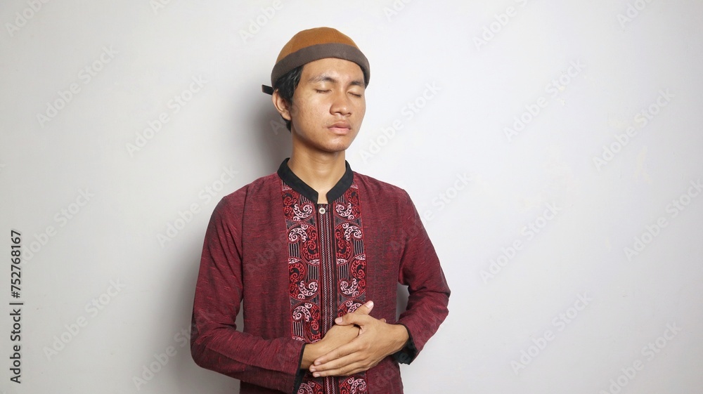 Obraz premium Asian Muslim man gesturing with stomach ache