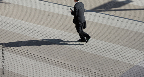 朝の街で急ぐ歩く一人のサラリーマンの姿