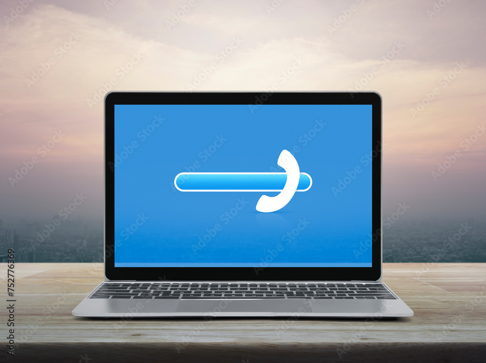 Phone icon with copy space for add your phone number on modern laptop computer monitor screen on wooden table over office city tower and skyscraper at sunset sky, vintage style, Business contact us