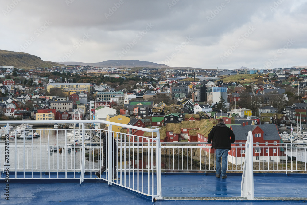 Fototapeta premium Panoramic scenic coastal view over Thorshavn, Faroe Island city skyline and other rocky isles with lush green meadows Danish territory in Atlantic Ocean seen from cruiseship cruise ship liner