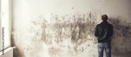 Man Contemplating in Front of a Grungy Wall Covered in Mold and Mildew © Ilgun