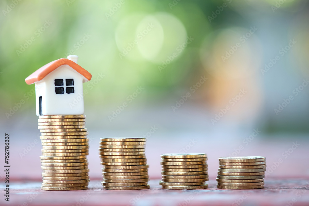 Mini house on growth of stack of coins. Real estate, Property investment and asset management, Refinance, Loan, Mortgage, Inflation, Sale and tax rise, Business and finance concept. Mini house on growth of stack of coins. Real estate, Property investment and asset management, Refinance, Loan, Mortgage, Inflation, Sale and tax rise, Business and finance concept.