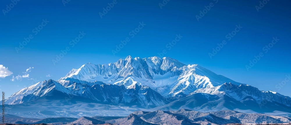 Obraz premium Panoramic view of pristine snow-covered mountain peaks under blue sky
