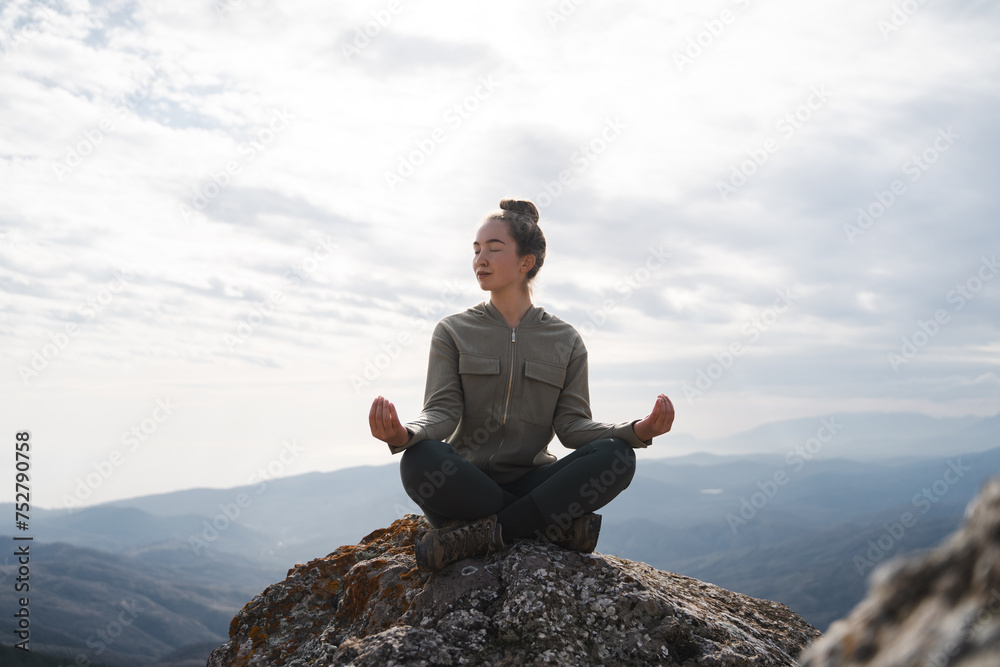 Yoga outdoors. Woman sits in lotus position zen gesturing. Concept of healthy lifestyle and relaxation. Meditation in the mountains